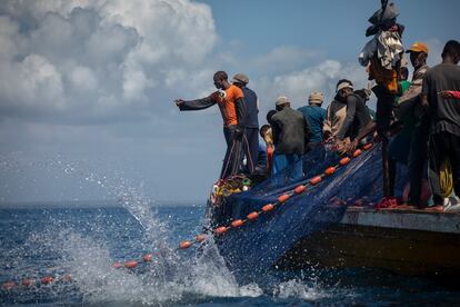 Pescadores de Tanga en alta mar recogen la red de pesca con decenas de atunes.