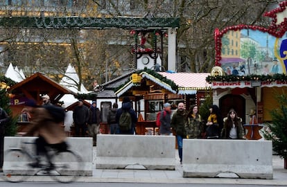 El Breitscheidtplatz tendrá nuevas medidas de seguridad, entre ellas la colocación de bloques de cemento en todo su perímetro. En la imagen, gente caminando tras las barreras de protección instaladas para garantizar la seguridad en el mercado navideño.