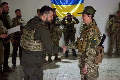 El presidente ucranio Zelenski condecora a una soldada en Járkov. 