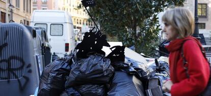 Una torre de bolsas de basura, coronada por una irónica imagen.