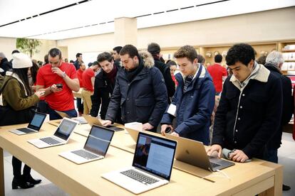 Clientes mirando MacBooks Pro.