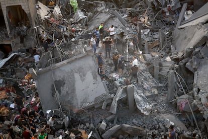 Decenas de personas buscaban supervivientes entre los escombros de varios edificios destruidos este domingo en el campo de refugiados de Al Magazi.