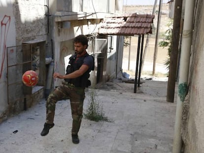 Un rebelde juega al f&uacute;tbol en el frente de Alepo (Siria), en julio de 2014.