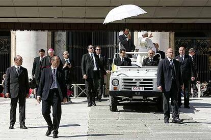 Benedicto XVI, rodeado de guardaespaldas, tras la audiencia general celebrada ayer en la plaza de San Pedro.