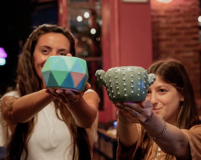 Dos jóvenes muestran la taza que acaban de pintar en un taller de Proyecto Objeto, en una imagen cedida.