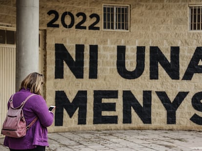 Una mujer pasa por delante de una pared donde se puede leer "Ni una menos" en un acto en memoria de las víctimas de violencia de género y sus hijas e hijos, en el antiguo cauce del Turia, el pasado 8 de marzo en Valencia.