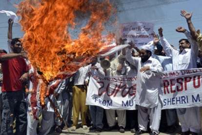 Un grupo de activistas quema una bandera estadounidense en protesta por el ataque con aviones no tripulados de la CIA en Pakistán.