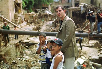 El Príncipe de Asturias visita uno de los barrios de Caracas afectados por las inundaciones que devastaron Venezuela, acompañado por varios niños supervivientes.