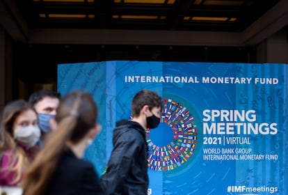 Varios jóvenes pasan ante la sede del FMI en Washington, este lunes.