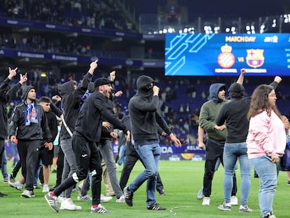 Radicales del Espanyol invaden el terreno de juego tras el derbi ante el Barcelona.