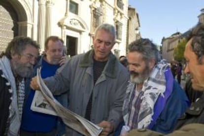 El diputado andaluz de IU Juan Manuel Sánchez Gordillo (d) y el portavoz del Sindicato Andaluz de Trabajadores (SAT), Diego Cañamero (c), leen la prensa junto a otros jornaleros ante la sede del Tribunal Superior de Justicia de Andalucía (TSJA) en Granada, el 12 de noviembre de 2013. EFE/Archivo