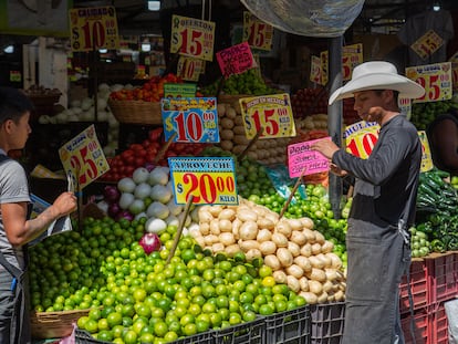 Vendedores atiende un puesto de verduras en el mercado de la Merced, en Ciudad de México.