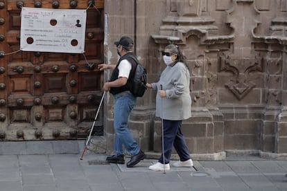 Dos personas ciegas caminan por el centro histórico de la Ciudad de México.