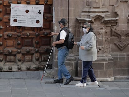 Dos personas ciegas caminan por el centro histórico de la Ciudad de México.