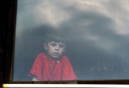 Una nena siriana mira per la finestra d'un centre de refugiats a Presevo, Sèrbia.