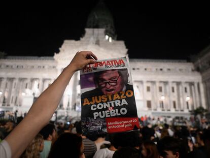 Un hombre muestra un diario con una fotografía de Javier Milei y el titular "Ajustazo contra el pueblo", durante una protesta en Buenos Aires, el pasado 21 de diciembre.