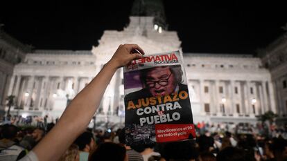 Un hombre muestra un diario con una fotografía de Javier Milei y el titular "Ajustazo contra el pueblo", durante una protesta en Buenos Aires, el pasado 21 de diciembre.