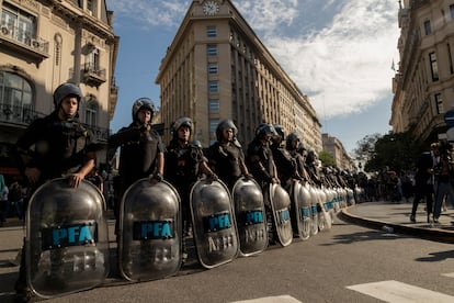 Policías acordonan una calle para evitar el paso de manifestantes.