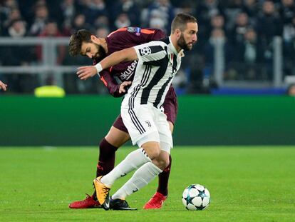 Gonzalo Higuain, jugador del Juventus, es presionado por el defensa del Barcelona Gerardo Piqué