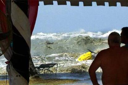 Dos turistas contemplan cómo el maremoto llega a la costa, el domingo, en el noroeste de Malaisia.