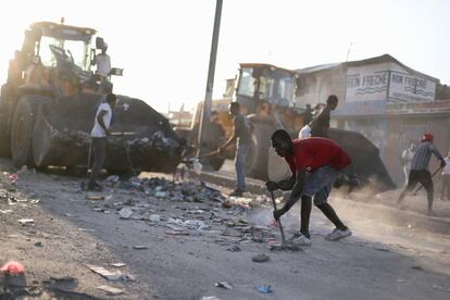 El Gobierno haitiano ha llamado a la ciudadanía a reanudar las actividades después 11 días de protestas continuadas en Puero Príncipe. Durante la noche del sábado el primer ministro de Haití anunció en un discurso a la nación una serie de medidas para tratar de paliar la crisis económica y luchar contra la corrupción en un intento por bajar la tensión política de los últimos días. En la imagen, los trabajadores limpian para desbloquear una calle tras las protestas antigubernamentales de este lunes en Puerto Príncipe