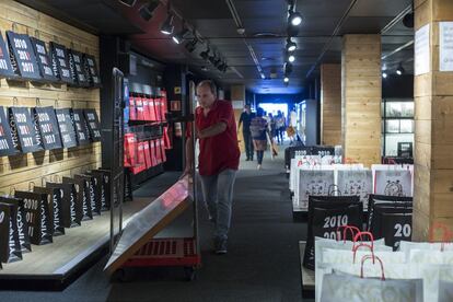 Un trabajador traslada una estantería vacía mientras los clientes echan el último vistazo a la tienda, ya vacía de sus habituales productos de diseño para el hogar o la oficina.