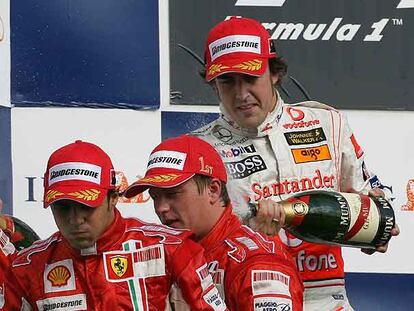 Fernando Alonso riega con champaña a Felipe Massa y Kimi Raikkonen.