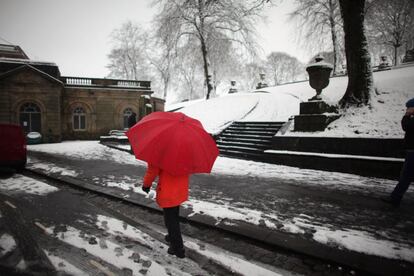 Un viandante pasea por las calles nevadas de la ciudad británica de Buxton.