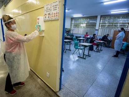 Mãe de aluno, contratada em um programa de temporários da Prefeitura, desinfeta um recipiente de álcool gel na escola de ensino fundamental Sylvia Martin Pires em São Paulo, em 8 de março de 2021.