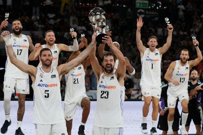 Los jugadores del Real Madrid Sergio Llull y Rudy Fernández levantan el trofeo tras su victoria ante el Barcelona.