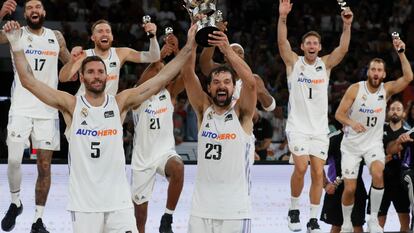 Los jugadores del Real Madrid Sergio Llull y Rudy Fernández levantan el trofeo tras su victoria ante el Barcelona.