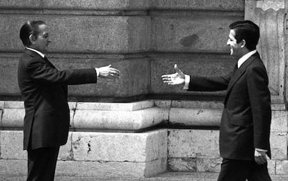 Torcuato Fernández Miranda (i) espera con su mano tendida al presidente del Gobierno, Adolfo Suárez, que camina hacia él sonriente y con la mano tendida para saludarse durante la recepción al presidente de Portugal, general Antonio Ramalho Eanes, en el Palacio Real de Madrid el 23 de mayo de 1977.