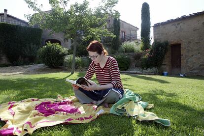 Una mujer lee en el jardín de la casa "Cal Prat Barrina", en la Sierra de Castelltallat, en la provincia de Barcelona.