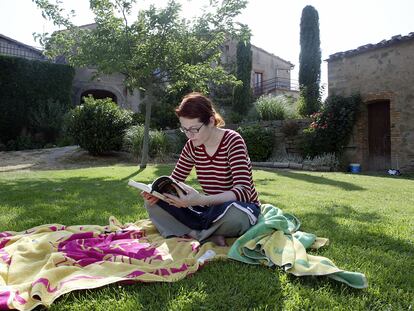 Una mujer lee en el jardín de la casa "Cal Prat Barrina", en la Sierra de Castelltallat, en la provincia de Barcelona.