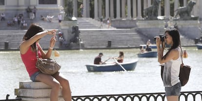 Dos turistas se fotografían en el Parque del Retiro, en Madrid. 