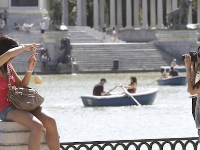 Dos turistas se fotografían en el Parque del Retiro, en Madrid. 