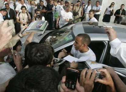 Lewis Hamilton firma autógrafos a la salida del circuito de Melbourne.