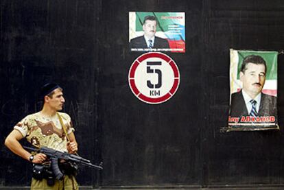 Un policía checheno vigila una calle de Grozni ante un cartel electoral del presidente, Alú Aljánov.