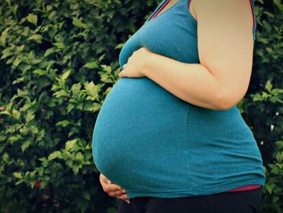 Una mujer muestra su avanzado estado de gestación.