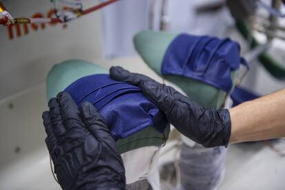 Una trabajadora de la Sociedad Textil Lonia, fabricante de las marcas Purificación García y Carolina Herrera, en Pereiro de Aguiar (Ourense), realiza el planchado de una mascarilla.