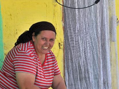 Una mujer prepara el pescado a la puerta de su casa.