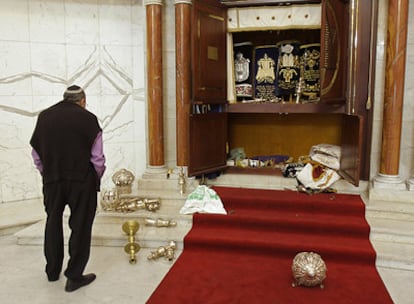 Un miembro de la comunidad judía venezolana observa el tabernáculo vandalizado en la sinagoga de Caracas