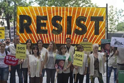 Los manifestantes de Greenpeace se quedan en silencio con pancartas frente a la embajada estadounidense de Madrid como protesta a la decisión de Donald Trump.