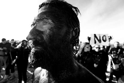 Retrato de uno de los activistas con la cara cubierta de petróleo ante un grupo de voluntarios que se sumaron a la protesta contra las prospecciones petrolíferas en las costas de Baleares y golfo de Valencia.