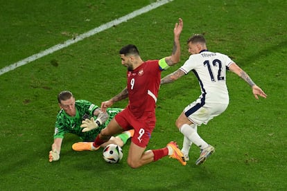 Aleksandar Mitrovic de Serbia conduce la pelota ante los ingleses Kieran Trippier y Jordan Pickford.