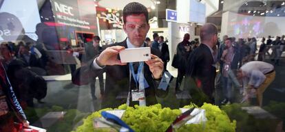 Un visitante toma una foto a unos smartphones durante el MWC del a&ntilde;o pasado. Miles de ejecutivos de la industria vuelven a congregarse esta semana en Barcelona.