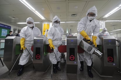 Trabajadores con trajes especiales para evitar el contagio del coronavirus durante los trabajos de limpieza del metro de Seúl (Corea del Sur), el 28 de febrero.