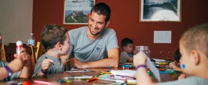 Un voluntario universitario participa en actividades con niños en un centro de acogida de menores. 