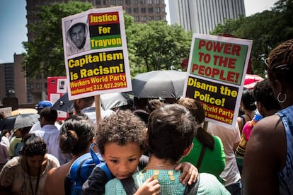 Una mujer sostiene un ni&ntilde;o mientras asiste a un mitin en apoyo a Trayvon Martin, organizado por el reverendo Al Sharpton en Nueva York para prrotestar por el  veredicto de no culpabilidad de George Zimmerman.