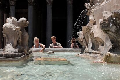 Unos turistas, junto a una fuente en Roma (Italia). Temperaturas de 40º C envuelven Europa y Asia.